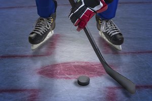 Un jugador de hockey hace un tiro para anotar un tanto.