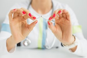 Imagen de una mujer rompiendo un cigarrillo con sus manos