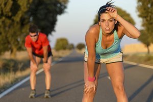 Una pareja toma aire después de una carrera en una carretera.