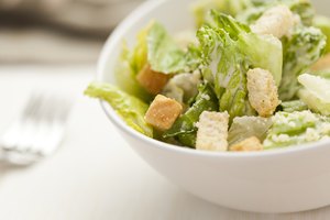 Ensalada saludable con cuadraditos de pan.