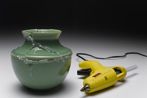 Coloca la cabeza de la llave cerca del encendido sosteniendo la pistola de silicona.