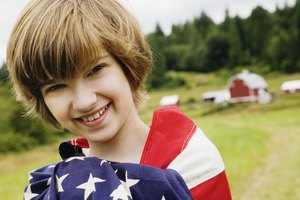 Girl wrapped in American flag on farm