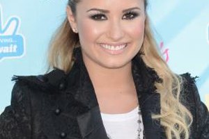 Jason Merritt/Getty Images Entertainment/Getty Images Demi Lovato goes for a casual look with her black lace blazer by pairing it with a simple white tee.