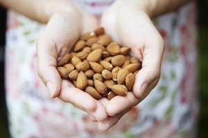 Las manos de la mujer están llenas de almendras.