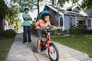 Jupiterimages/Brand X Pictures/Getty Images Children need training wheels at first but as balance improves they lose the training wheels around age 8.