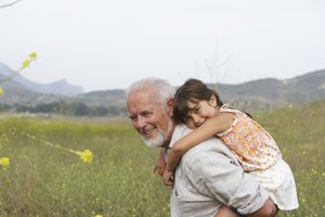 Grandfather giving girl (4-6) piggyback, smiling, portrait, side view