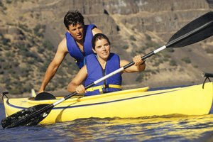 Una pareja agotada remando un kayak.
