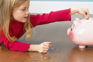 Girl putting coins in piggy bank