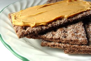 Unta la mantequilla de maní sobre las galletas graham