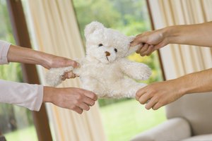 Hands pulling teddy bear