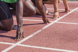 Dos corredores preparados para correr en la línea de largada de la pista.