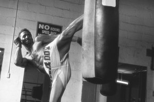 Si te encuentras sin un compañero de entrenamiento en el gimnasio, una bolsa pesada se hace un blanco desafiante con el cual practicar patadas laterales.