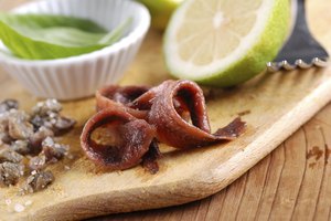 Filetes de anchoas sobre tabla de cortar.
