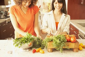 Dos amigas preparando una comida con vegetales