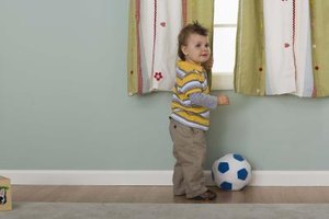 Jupiterimages/Comstock/Getty Images Clearing the area below the window of furniture makes it more difficult for your toddler to climb out.