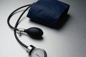 Un médico encuentra la presión arterial diastólica y sistólica con el tensiómetro.