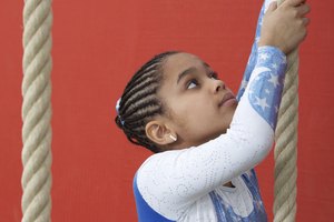 En vez de levantar pesas, las jovenes gimnastas suben cuerdas para desarrollar su fuerza.