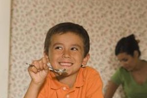 Brand X Pictures/Brand X Pictures/Getty Images Establishing a morning routine, such as eating breakfast at a certain time each day, can help your child stay in bed until it is time to get up.