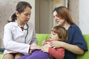 Un médico examina el estómago de un niño.