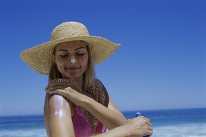 Una joven aplicandose protector solar en los brazos y cara