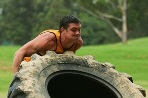 Tira neumáticos de tractor como parte de un entrenamiento paleo.