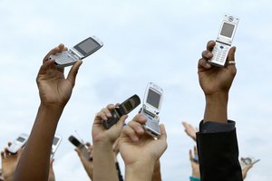 Personas sosteniendo teléfonos móviles en el aire.