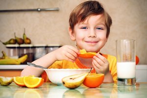Un niño comiendo rodajas de naranja.