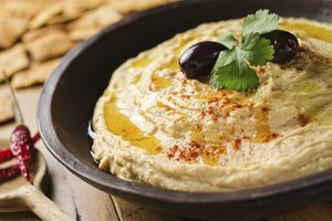 Hummus con hierbas, aceite de oliva y aceitunas.