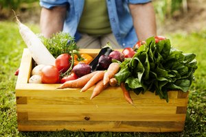 Jardinero que sostiene una caja de verduras.