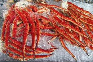 Las patas de cangrejo enormes se extienden sobre hielo en un mercado.