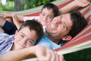 Smiling father and sons in hammock