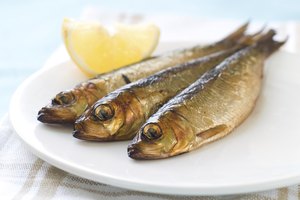 Sardinas en un plato con una rodaja de limón.
