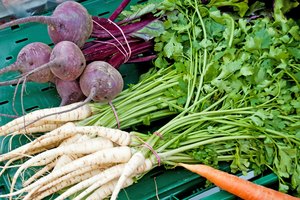 Pila de verduras de raíz sobre una mesa.