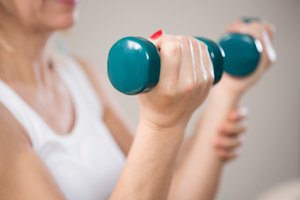 Una mujer ejercitando sus bíceps con dos pesas pequeñas