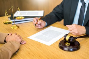 couple problems sitting a marriage Golden wedding rings judge gavel deciding on marriage divorce signing divorce documents or premarital agreement provide legal advice of lawyer and consoling to his clients.