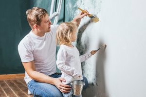 Family, happy daughter with dad doing home repair, paint walls,