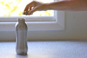 Vierte una gota de aceite de limón en una botella de agua para limpiarla.