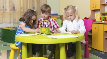 Preschool students sitting at table in classroom.