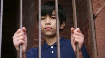 Child standing behind bars