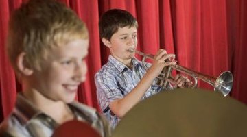 Boys playing instruments at a talent show.