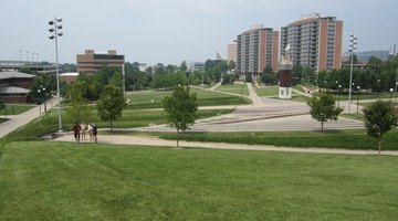 Campus Green, which is green and activity space for students at UC. To the left is the Lindner College of Business, and to the right are residence halls.