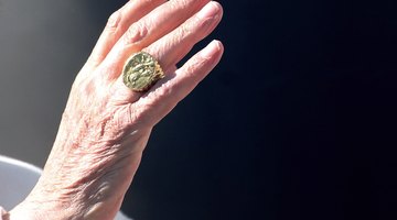 A close-up of a pope's gold ring.