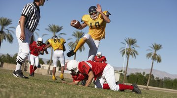 Football player jumping over a player.