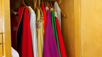 Various clergy robes hang in a closet.