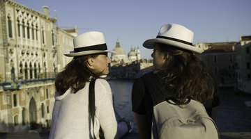 Two tourists conversing on a bridge in Venice, Italy.