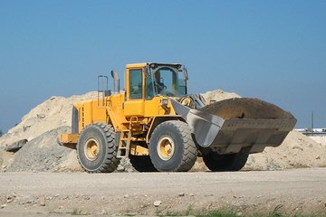A front loader hauls dirt on a construction site. A front loader hauls dirt on a construction site.