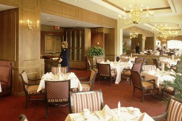 A hostess does preparatory work before dinner service starts. A hostess does preparatory work before dinner service starts.