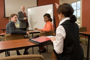 Woman asking question in classroom Woman asking question in classroom