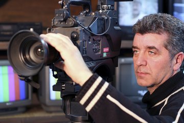 A movie producer holding a professional video camera. A movie producer holding a professional video camera.