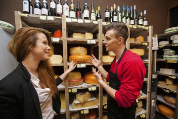 A variety of cheeses and maybe some wines can be found in a specialty cheese shop. A variety of cheeses and maybe some wines can be found in a specialty cheese shop.